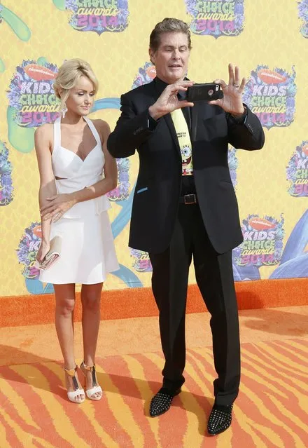 Actor David Hasselhoff takes a picture as he arrives with Hayley Roberts at the 27th Annual Kids' Choice Awards in Los Angeles, California March 29, 2014. (Photo by Danny Moloshok/Reuters)