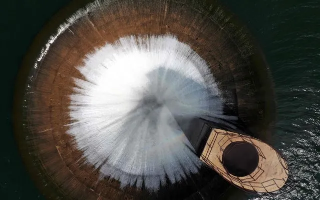 An aerial view from a drone shows water from the artificial Qaraaoun lake running into the overflow pipe near the dam in the west of Lebanon's Bekaa Valley, on April 5, 2019. The abundance of rain this year led to an overflow drainage in one of the biggest dams in Lebanon. (Photo by Joseph Eid/AFP Photo)