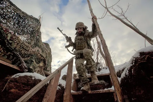 A service member of the Ukrainian armed forces walks at combat positions near the line of separation from Russian-backed rebels near Horlivka in the Donetsk region, Ukraine, January 22, 2022. (Photo by Anna Kudriavtseva/Reuters)