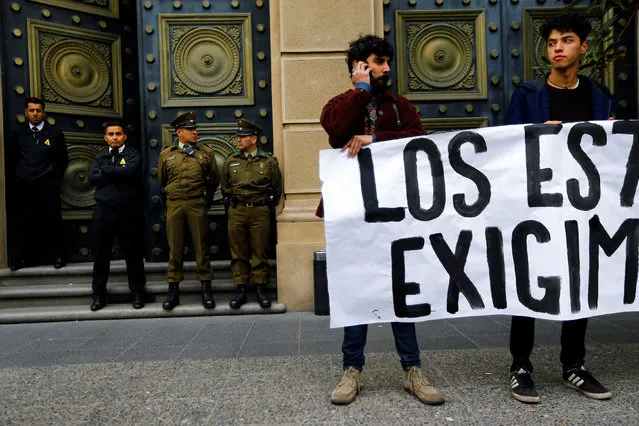 Student protesters hold a banner outside the ministry of finance building during a rally to demand changes in the education system in Santiago, Chile April 28, 2016. The words on the banner are part of a slogan that says, “Students demand dignity”. (Photo by Ivan Alvarado/Reuters)