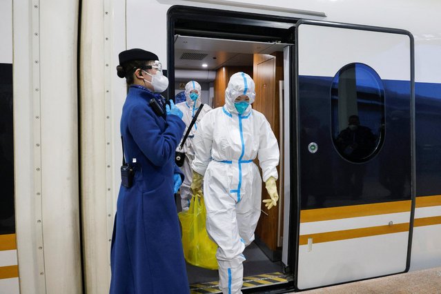 Railway staff members wearing personal protective equipment, leave a high-speed train at Zhangjiakou cluster train station inside a closed loop area designed to prevent the spread of the coronavirus disease (COVID-19) in Zhangjiakou, China January 27, 2022. (Photo by Tyrone Siu/Reuters)