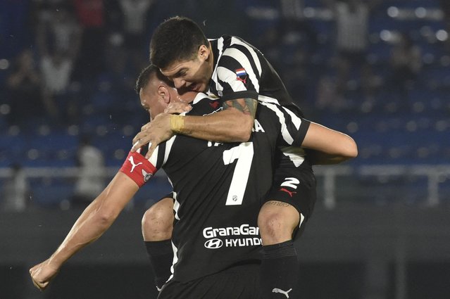 Libertad's forward Oscar Cardozo (L) celebrates with teammate defender Ivan Ramirez after scoring his team's second goal during the Paraguay First Division Apertura Tournament football match between Olimpia and Libertad at the Defensores del Chaco stadium in Asuncion on June 5, 2024. (Photo by Norberto Duarte/AFP Photo)