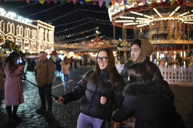 Visitors make a selfie as they walk in Red Square in Moscow, Russia, Monday, February 14, 2022. (Photo by Alexander Zemlianichenko/AP Photo)