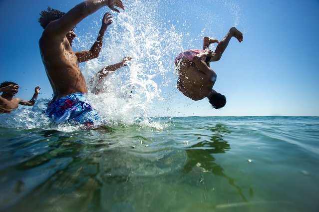 A group of boys toss their friend into the water at Good Harbor Beach in Gloucester, Massachusetts, United States on June 25, 2024. New England temperatures reached into the high 80's(F) and low 90's(F) this week after a heatwave brought temperatures close to 100(F) last week. Heat domes causing heatwaves have been hitting the US over the past week with high alerts placed in the I-95 corridor on the East Coast. The National weather service has predicted above-normal temperatures for most the US for the month of July. (Photo by Joseph Prezioso/Anadolu via Getty Images)