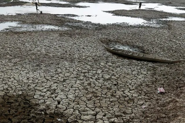 Fishermen throw their net to catch fish at a Bak Angrout dried up pond at the drought-hit Kandal province in Cambodia May 13, 2016. (Photo by Samrang Pring/Reuters)