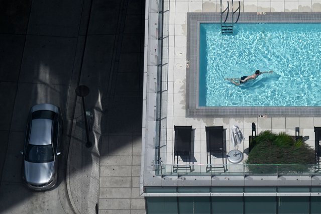 A swimmer cools off in a pool as the street below is seen at left on Sunday June 9, 2024 in Arlington, VA. (Photo by Matt McClain/The Washington Post)