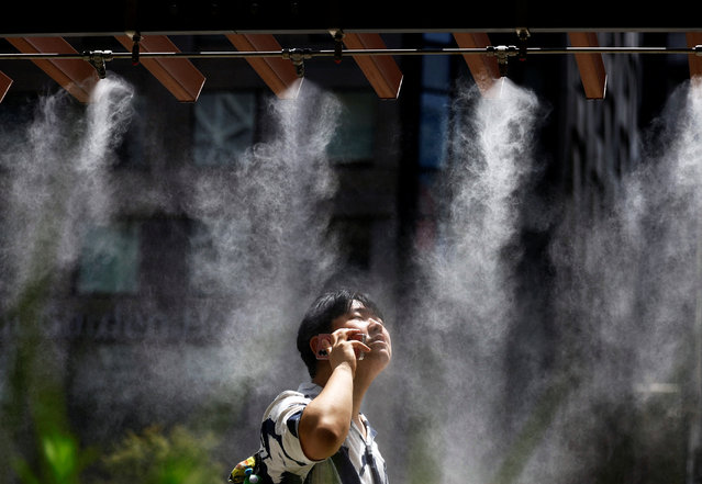 A man takes a break under a cooling mist as the Japanese government issued a heatstroke alert in Tokyo and other prefectures, in Tokyo, Japan on July 9, 2024. (Photo by Issei Kato/Reuters)