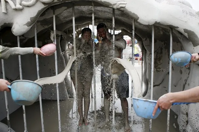 Tourists takes a mud shower during the Boryeong Mud Festival at Daecheon beach in Boryeong, South Korea, July 18, 2015. (Photo by Kim Hong-Ji/Reuters)