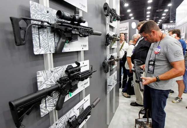 Gun enthusiasts look over Sig Sauers guns at the National Rifle Association's annual meetings & exhibits show in Louisville, Kentucky, May 21, 2016. (Photo by John Sommers II/Reuters)