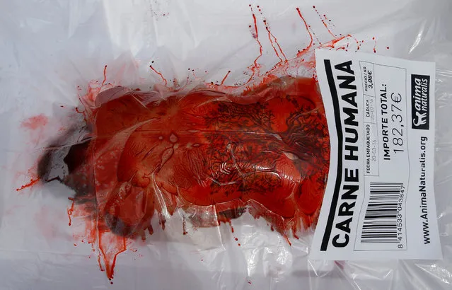 An animal rights activist, wrapped in packaging labelled “carne humana” (human meat),  participates in a protest against meat consumption to promote vegetarianism in central Barcelona, in Spain, May 22, 2016. (Photo by Albert Gea/Reuters)