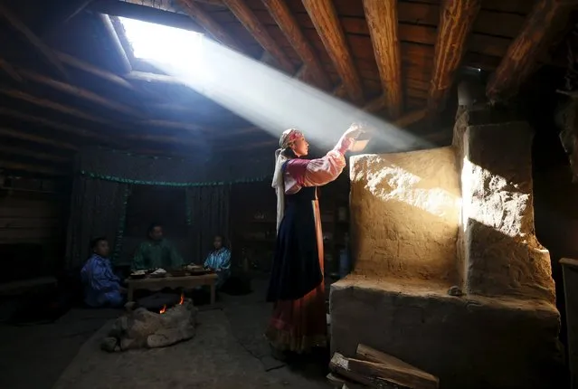 Members of national folklore and ethnographic groups and employees of a museum-preserve participate in the reconstruction of daily life and traditional holidays celebrated by indigenous population of the Republic of Khakassia during a demonstration for visitors outside Kazanovka village, southwest of the city of Abakan, Russia, July 24, 2015. (Photo by Ilya Naymushin/Reuters)