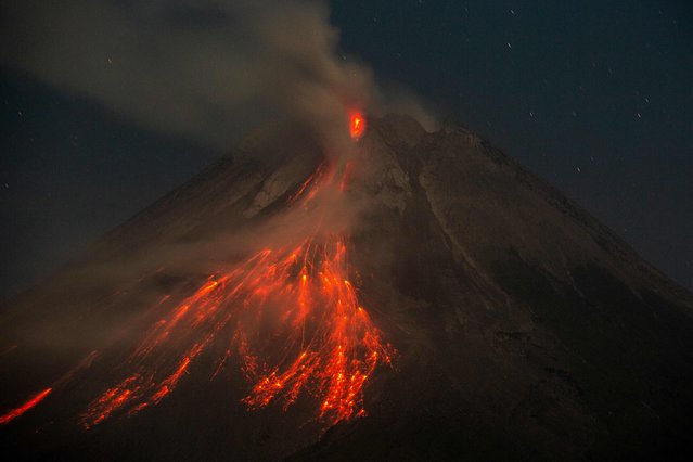 Mount Merapi spews lava onto its slopes as seen from Wonokerto, Yogyakarta on July 19, 2024. (Photo by Devi Rahman/AFP Photo)