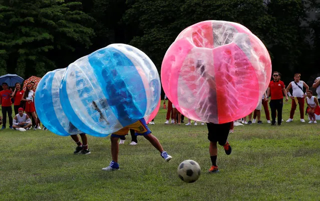 Employees of a company and their families play a friendly game of bubble bump soccer at the University of the Philippines school campus in Quezon city, Metro Manila, Philippines June 14, 2016. (Photo by Erik De Castro/Reuters)