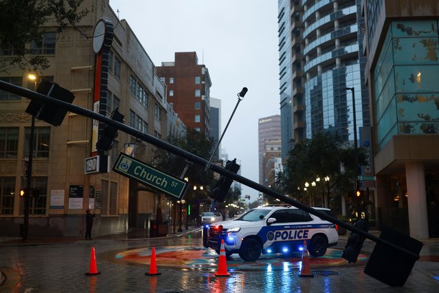 A view shows a fallen traffic light near a police car, after Hurricane Milton made landfall in Florida, in Orlando on October 10, 2024. (Photo by Jose Luis Gonzalez/Reuters)