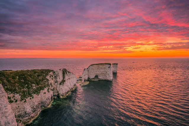 Sunrise at Old Harry Rocks near Swanage on Dorset’s Jurassic Coast in UK on Monday morning, July 15, 2024. They are said to take their name from either the devil, a pirate from Poole called Harry Paye, or Earl Harold, a Viking raider. (Photo by Alister Gooding/Picture Exclusive)