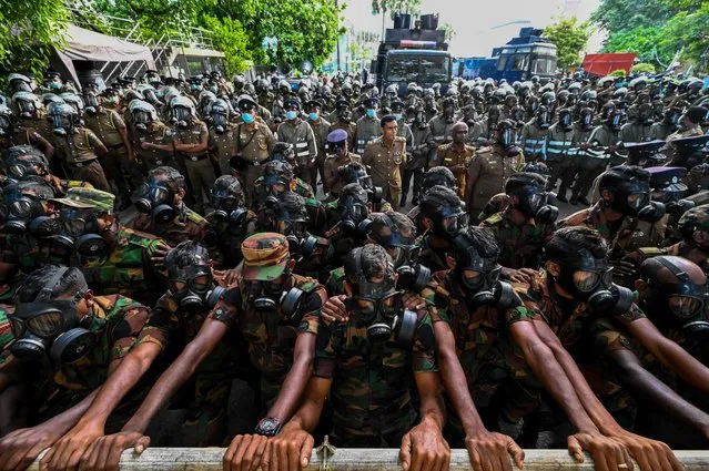 Soldiers stand guard behind barriers as protesters gather during the 50th day of anti-government protests demanding the resignation of Sri Lanka's President Gotabaya Rajapaksa over the country's crippling economic crisis, in Colombo on May 28, 2022. (Photo by Ishara S. Kodikara/AFP Photo)
