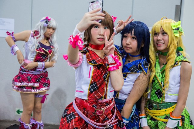Cosplay fans (R) take selfies as comic book and gaming fans attend the annual Ani-Com and Games Fair in Hong Kong on July 28, 2017. Tens of thousands were expected to attend the annual event on animation, comics and games, from July 28 to August 1. (Photo by Isaac Lawrence/AFP Photo)