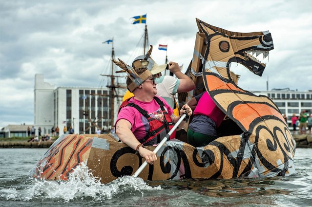 Competitors race during the Great Salem Maritime Cardboard Boat Regatta as part of the at Salem Merry-time Fest in Salem, Massachusetts on August 19, 2023. The custom boats made from corrugated cardboard and duct tape, must fit at least two people and compete in a set of heats, racing from Derby Beach to a buoy and back to the beach to win prizes. (Photo by Joseph Prezioso/AFP Photo)