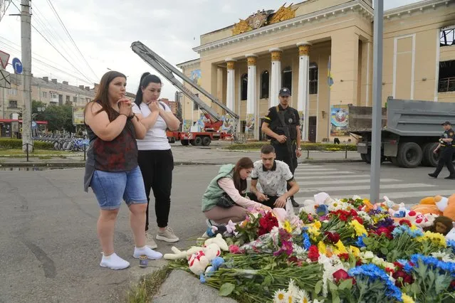 People pray and lay flowers at the site of a Russian shelling on Thursday, in Vinnytsia, Ukraine, Friday, July 15, 2022. Russian missiles struck the city of Vinnytsia in central Ukraine on Thursday, killing at least 23 people and injuring more than 100 others, Ukrainian officials said. (Photo by Efrem Lukatsky/AP Photo)