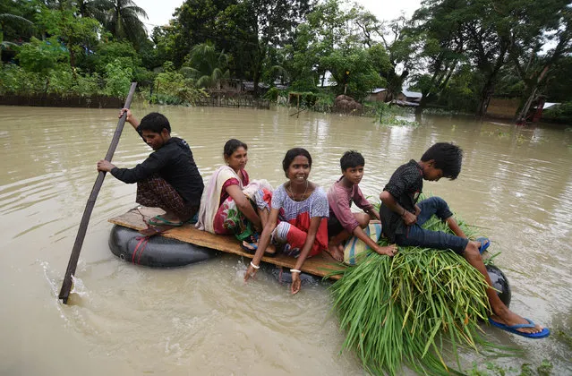 People use makeshift boats as they try to move to safer places along a flooded road in Jakhalabandha area in Nagaon district, Assam, August 14, 2017. (Photo by Anuwar Hazarika/Reuters)