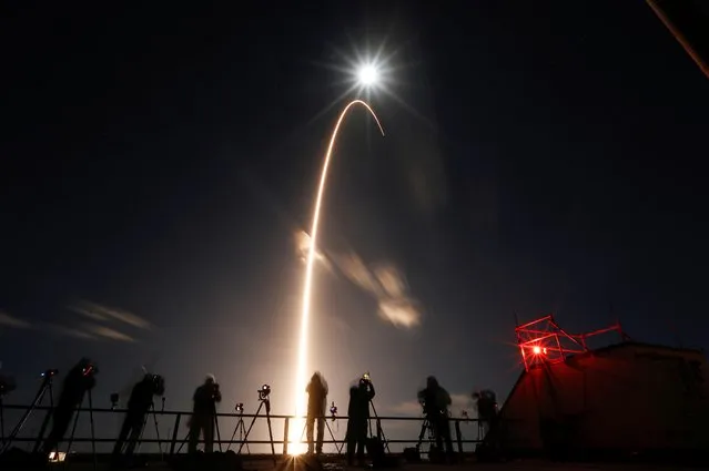 The Solar Orbiter spacecraft, built for NASA and the European Space Agency, lifts off from pad 41 aboard a United Launch Alliance Atlas V rocket at the Cape Canaveral Air Force Station in Cape Canaveral, Florida, U.S., February 9, 2020. The full moon is shown above. (Photo by Joe Skipper/Reuters)
