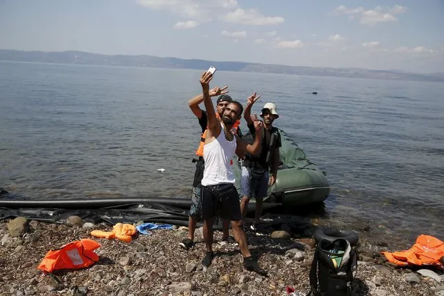 Syrian refugees from Kobani pose for a “selfie”, moments after arriving on a dinghy on the island of Lesbos, Greece August 23, 2015. Greece, mired in its worst economic crisis in generations, has been found largely unprepared for a mass influx of refugees, mainly Syrians. Arrivals have exceeded 160,000 this year, three times as high as in 2014. The crisis has exposed massive shortages in Greece's available facilities, but also striking discord within the European Union on how to handle the humanitarian crisis. (Photo by Alkis Konstantinidis/Reuters)