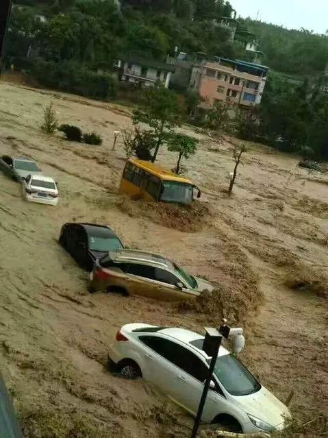 This image taken with a cameraphone shows cars and buses being washed away by floodwaters in Fuzhou, in eastern China's Fujian province on July 9, 2016. (Photo by AFP Photo/Stringer)