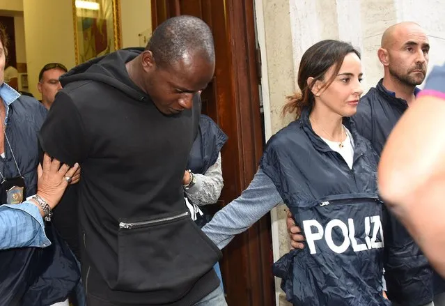 A man identified as Congolese refugee Guerlin Butungu is escorted by police officers as he leaves the police headquarters after being arrested in Rimini, Italy, Sunday, September 3, 2017. Police in Italy say they've arrested a Congolese refugee as the fourth suspect in gang rapes at a beach resort. Rimini police chief Maurizio Improta says the man was caught Sunday morning on a train about to leave a nearby town. On Saturday, the other three suspects, all minors, including two Moroccan teenage brothers, were detained in the rape of a Polish tourist, the savage beating of her companion and the rape of a Peruvian woman shortly after the first attack. (Photo by Manuel Migliorini/ANSA via AP Photo)