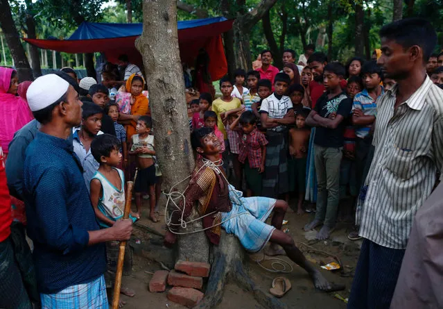 A man accused of stealing money from Rohingya refugees is tied to a tree at a makeshift refugee camp near Balukhali in Cox's Bazar, Bangladesh, September 13, 2017. (Photo by Danish Siddiqui/Reuters)