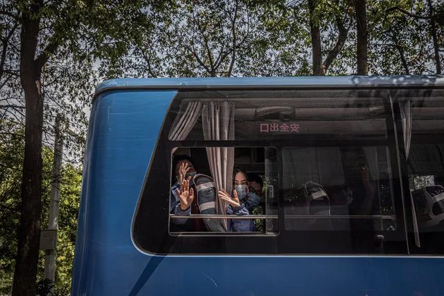 Chinese medical workers from Shandong province wave from a bus as they leave Wuhan, China, 06 April 2020. Wuhan, the epicenter of the coronavirus outbreak, will lift the lockdown on 08 April allowing people to leave the city after more than two months. (Photo by Roman Pilipey/EPA/EFE)