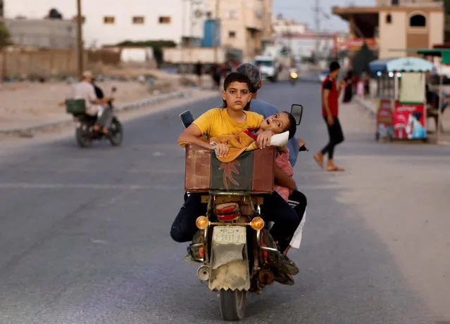 A Palestinian man carries his sons on a motorbike as a ceasefire between Israel and Islamic Jihad militants holds in the southern Gaza Strip on August 8, 2022. (Photo by Ibraheem Abu Mustafa/Reuters)