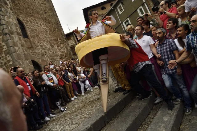 A dancer performs on stilts in honor of Saint Mary Magdalene in a street for the traditional “Danza de Los Zancos” (Los Zancos Dance), in the small town of Anguiano, northern Spain, Saturday, July 23, 2016. (Photo by Alvaro Barrientos/AP Photo)