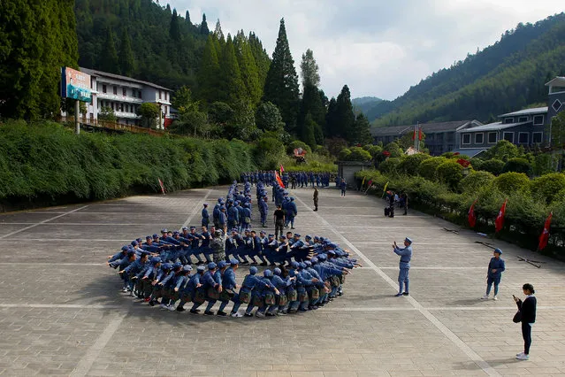 Participants dressed in replica red army uniforms take part in a Communist team-building course extolling the spirit of the Long March, organised by the Revolutionary Tradition College, in the mountains outside Jinggangshan, Jiangxi province, China, September 14, 2017. (Photo by Thomas Peter/Reuters)