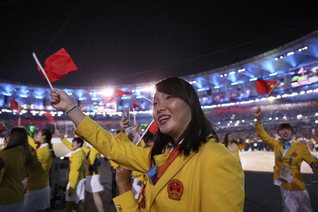 2016 Rio Olympics, Opening ceremony, Maracana, Rio de Janeiro, Brazil on August 5, 2016. An athlete from China waves her flag as she arrives in the stadium during in the opening ceremony. (Photo by Stefan Wermuth/Reuters)