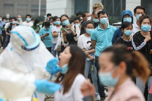 Staff members from the AOC computer monitor factory queue to be tested for the COVID-19 coronavirus in Wuhan in China's central Hubei province on May 15, 2020. Nervous residents of China's pandemic epicentre of Wuhan queued up across the city to be tested for the coronavirus on May 14 after a new cluster of cases sparked a mass screening campaign. (Photo by AFP Photo/China Stringer Network)