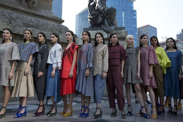 Models wearing creations by Mexican fashion house Yakampot pose together after a Mercedes-Benz Fashion Week show at the Angel of Independence monument, in Mexico City, Sunday, November 12, 2017. (Photo by Rebecca Blackwell/AP Photo)
