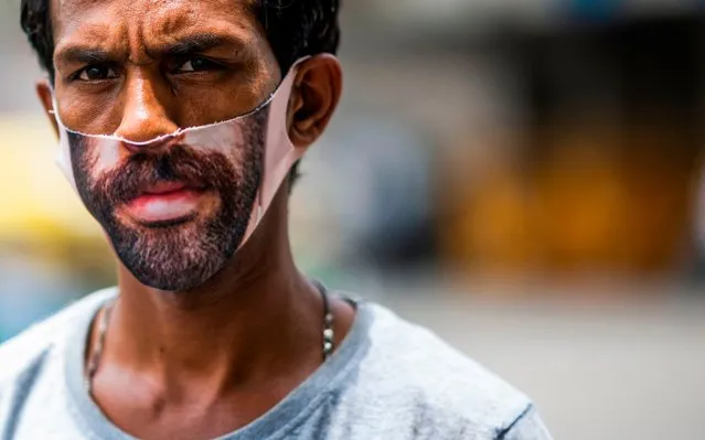 A man wearing a beard imprinted facemask as a preventive measure against the COVID-19 coronavirus walks along a street in New Delhi on June 19, 2020. India has recorded more than 380,000 cases of COVID-19, the fourth-highest in the world, with over 12,500 deaths, health ministry data show. (Photo by Jewel Samad/AFP Photo)
