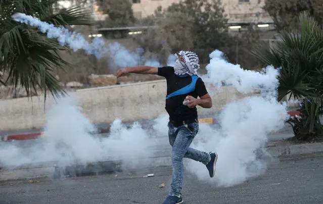 A Palestinian protester throws back a tear gas canister fired by Israeli troops during clashes in the occupied West Bank town of Al-Ram, near Jerusalem September 20, 2015. (Photo by Mohamad Torokman/Reuters)