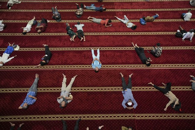 Muslim men rest after the first Friday prayer of the fasting month of Ramadan at Istiqlal Mosque in Jakarta, Indonesia, Friday, March 7, 2025. (Photo by Tatan Syuflana/AP Photo)