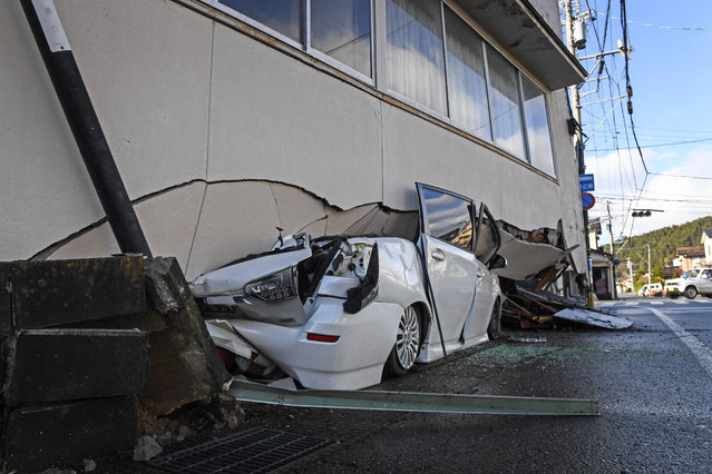 A car is seen under part of a building in Anamizu, Ishikawa prefecture on January 4, 2024, after a major 7.5 magnitude earthquake struck the Noto region in Ishikawa prefecture on New Year's Day. Japanese rescuers struggled with heavy rain, blocked roads and aftershocks on Wednesday following a powerful earthquake that killed at least 73 people and left tens of thousands without power or running water. (Photo by Toshifumi Kitamura/AFP Photo)