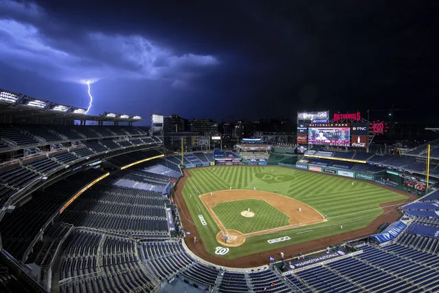 A bolt of lightning comes down from the clouds during the sixth inning of an opening day baseball game between the Washington Nationals and the New York Yankees at Nationals Park, Thursday, July 23, 2020, in Washington. (Photo by Alex Brandon/AP Photo)