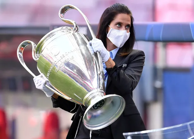 UEFA staff member carry away the trophy from the pitch prior the UEFA Champions League semi-final football match between Leipzig and Paris Saint-Germain at the Luz stadium in Lisbon on August 18, 2020. (Photo by David Ramos/Pool via AFP Photo)