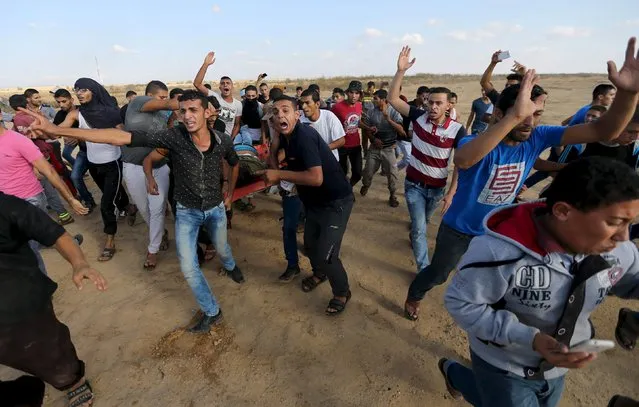 Palestinians evacuate the body of a Palestinian protester, who was shot and killed by Israeli troops during clashes, near the Israeli border fence in Khan Younis in the southern Gaza Strip October 9, 2015. Israeli troops shot dead five Palestinians in protests in Gaza on Friday and a knife-wielding Jewish man wounded four Arabs in southern Israel in a wave of violence that has fueled talk of a new uprising against Israeli occupation. (Photo by Ibraheem Abu Mustafa/Reuters)