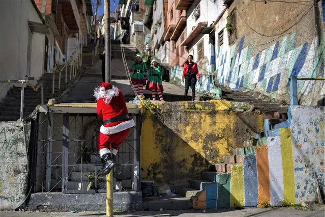 A man dressed as Santa Claus walks through one of the streets of the Barrio Las Palmas de El Cementerio community, during a walk to visit children and distribute toys in poor areas of Caracas, on December 24 December 2022. (Photo by Pedro Rances Mattey/Anadolu Agency via Getty Images)