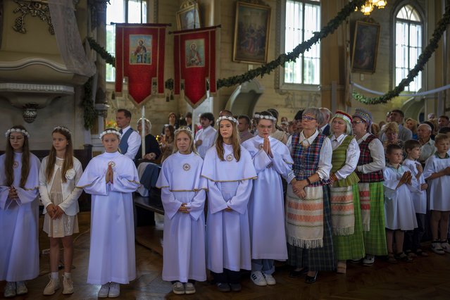 Catholic believers attend a Mass during the feast day of the St. Mary Magdalene at the Church of St. Matthew the Apostle Evangelist in the small town Veivirzenai, some 300km (186,4 miles) northwest of the capital Vilnius, Lithuania, Sunday, July 20, 2025. (Photo by Mindaugas Kulbis/AP Photo)