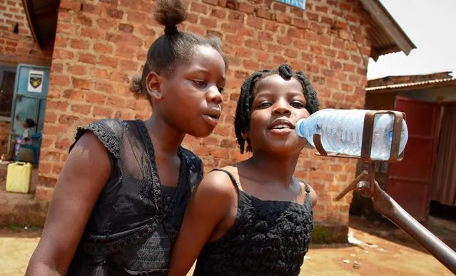 In this photo taken Wednesday, September 7, 2016, children in a band sing and make music to accompany the movies at the “Wakaliwood” studios in the Wakaliga slum of Kampala, Uganda. Deep in this Kampala slum at a tin-roofed collection of houses known as Wakaliwood, is the engine of Uganda's tiny film industry and the source of $200-budget movies and a glimmer of fame. (Photo by Stephen Wandera/AP Photo)