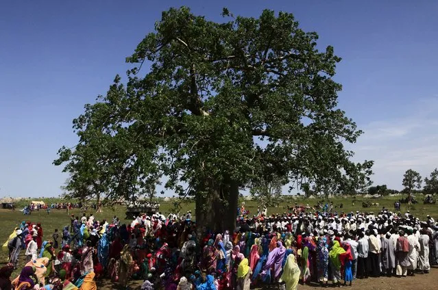 Displaced people gather to receive food provided by the United Nations' World Food Programme (WFP) during a visit by a European Union delegation, at an IDP camp in Azaza, east of Ad Damazin, capital of Blue Nile state, October 21, 2015. (Photo by Mohamed Nureldin Abdallah/Reuters)