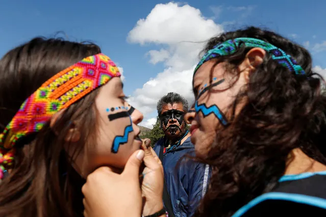 Dancers wearing pre-Hispanic themed clothing paint their faces before performing a ritual for corn, as they protest with Greenpeace volunteers against the growing of transgenic corn, or genetically modified corn, in the country during National Corn Day celebration at the archeological site of Teotihuacan, Mexico September 29, 2016. (Photo by Carlos Jasso/Reuters)