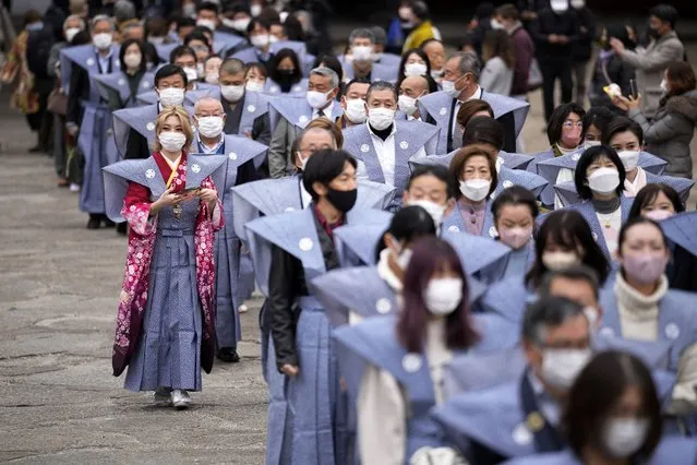 Bean scatterers march prior to the “Mame-maki”, a bean throwing ceremony, at the Zojoji Buddhist temple Friday, February 3, 2023, in Tokyo. The ritual believed to bring in good luck and drive away evil is performed annually to mark the beginning of the spring in the lunar calendar. (Photo by Eugene Hoshiko/AP Photo)