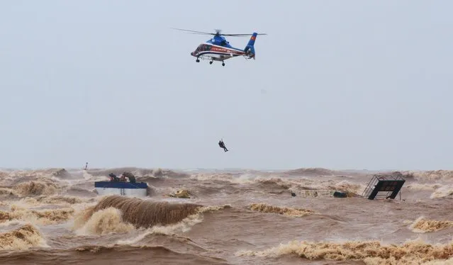A military helicopter rescues sailors of a submerged ship at Cua Viet Port in Quang Tri province, Vietnam on October 11, 2020. (Photo by Ho Cau/VNA via Reuters)